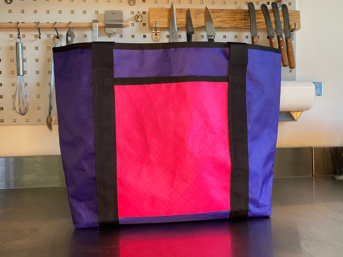 Eine lilafarbene Tragetasche mit pinken Fronttasche aus Ecopak, ideal zum Einkaufen beispielsweise.